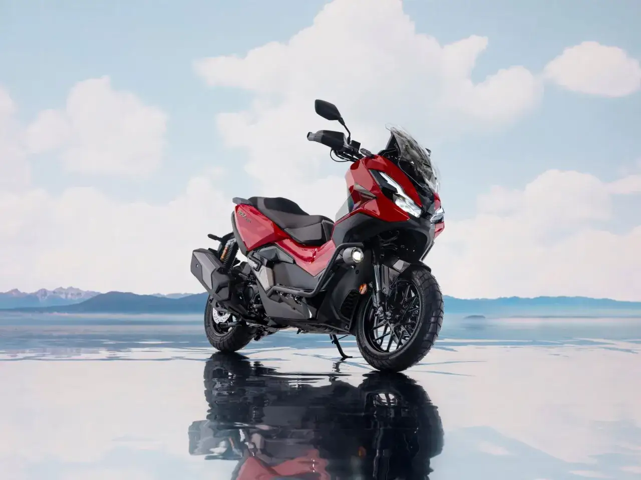 Motocicleta Zontes 368G roja, con reflejo en el agua, lista para explorar. Opiniones positivas la respaldan.