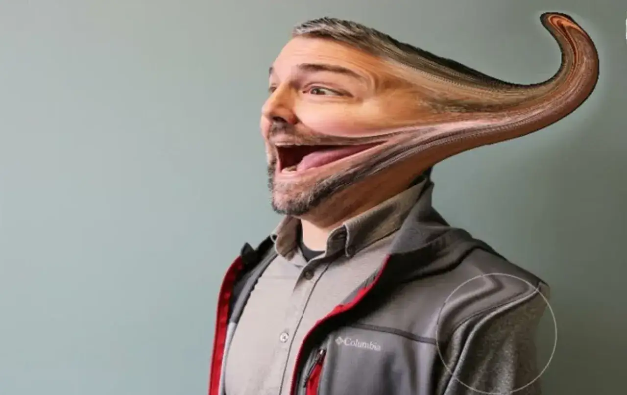 Un homme avec un visage déformé par l'outil Fluidité de Photoshop, tiré vers l'arrière comme une pâte à modeler.