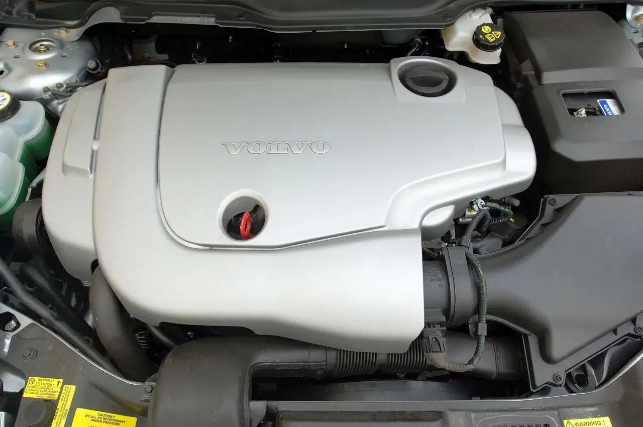 Silnik Volvo V50, często chwalony w **volvo v50 opinie**, wygląda na zadbany. Widać osłonę silnika z logo Volvo.