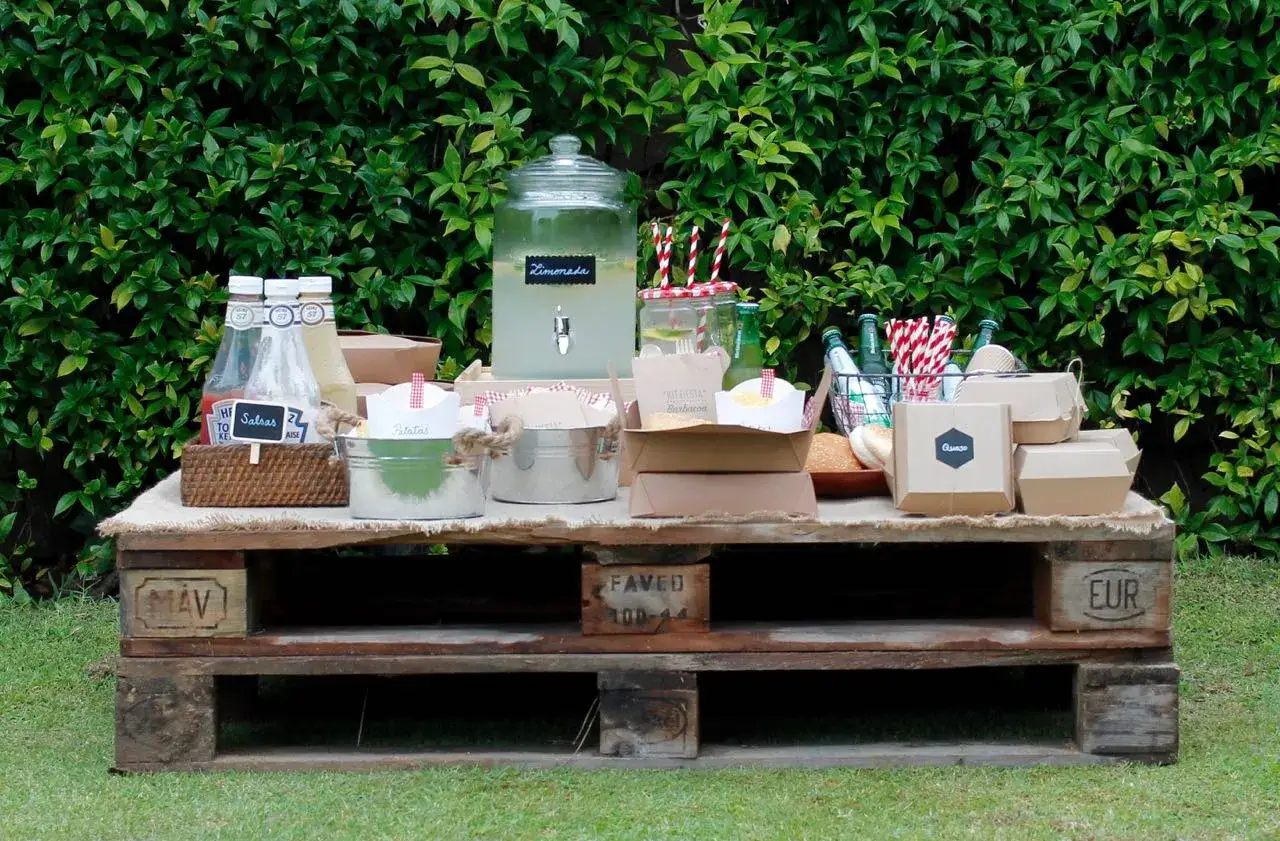 Mesa r&uacute;stica con limonada, salsas, patatas y hamburguesas. &iexcl;Todo listo para sorprender en una barbacoa!