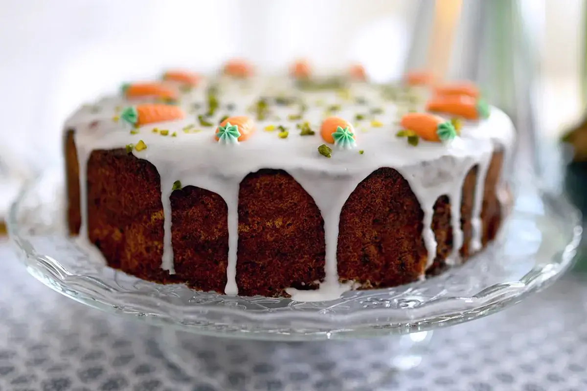 Torta di carote, perfetta per la tua prossima carrot cake ricetta. Glassa bianca colante e decorazioni a forma di carota.