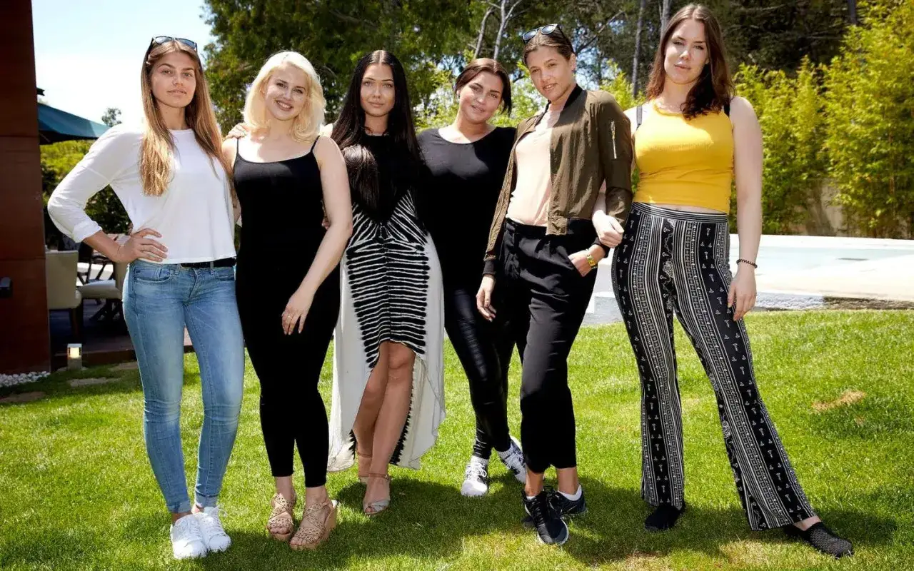 Sex unga kvinnor, potentiella top model sverige, poserar glatt utomhus i soligt väder.