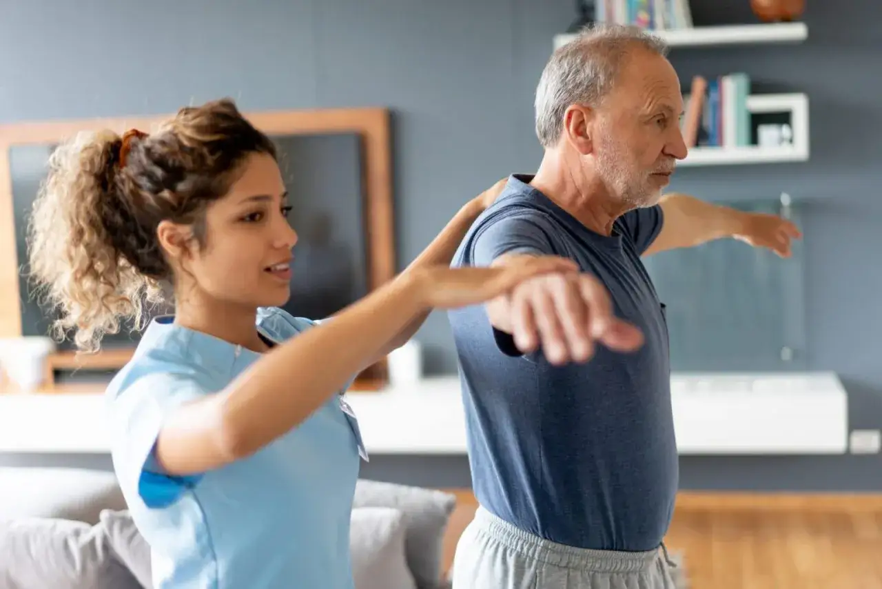 Fisioterapista aiuta un anziano a recuperare l'equilibrio, contrastando il senso di instabilità e sbandamento con esercizi mirati.