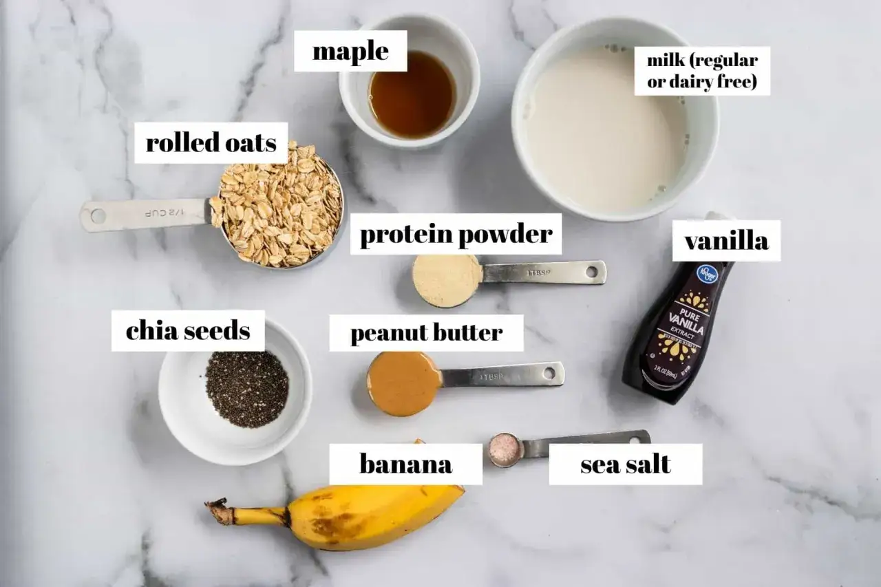 Zutaten f&uuml;r Overnight Oats mit Proteinpulver: Haferflocken, Chiasamen, Banane, Erdnussbutter, Ahornsirup, Meersalz, Milch, Vanilleextrakt.