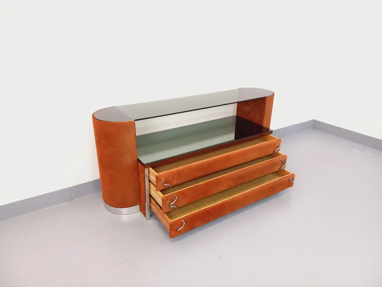 Mobile contenitore con piano in vetro fumé e cassetti rivestiti in camoscio arancione, un pezzo iconico di arredamento anni '70 italiano.