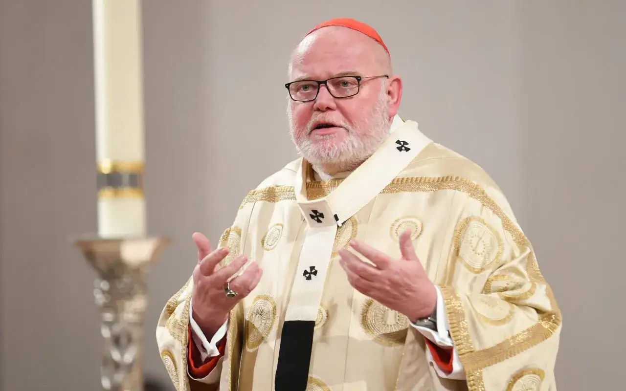 Kardinal Marx in festlicher Robe spricht mit ausdrucksstarker Geste.