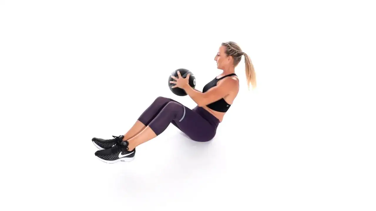 Frau macht Russian Twist mit Medizinball.