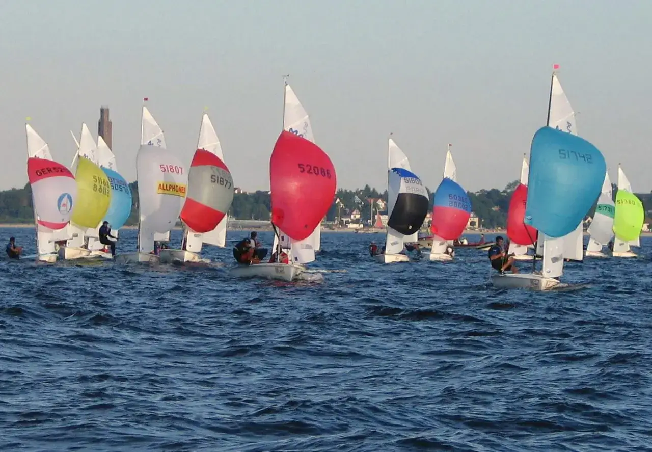 Segelboote mit bunten Spinnakern, darunter