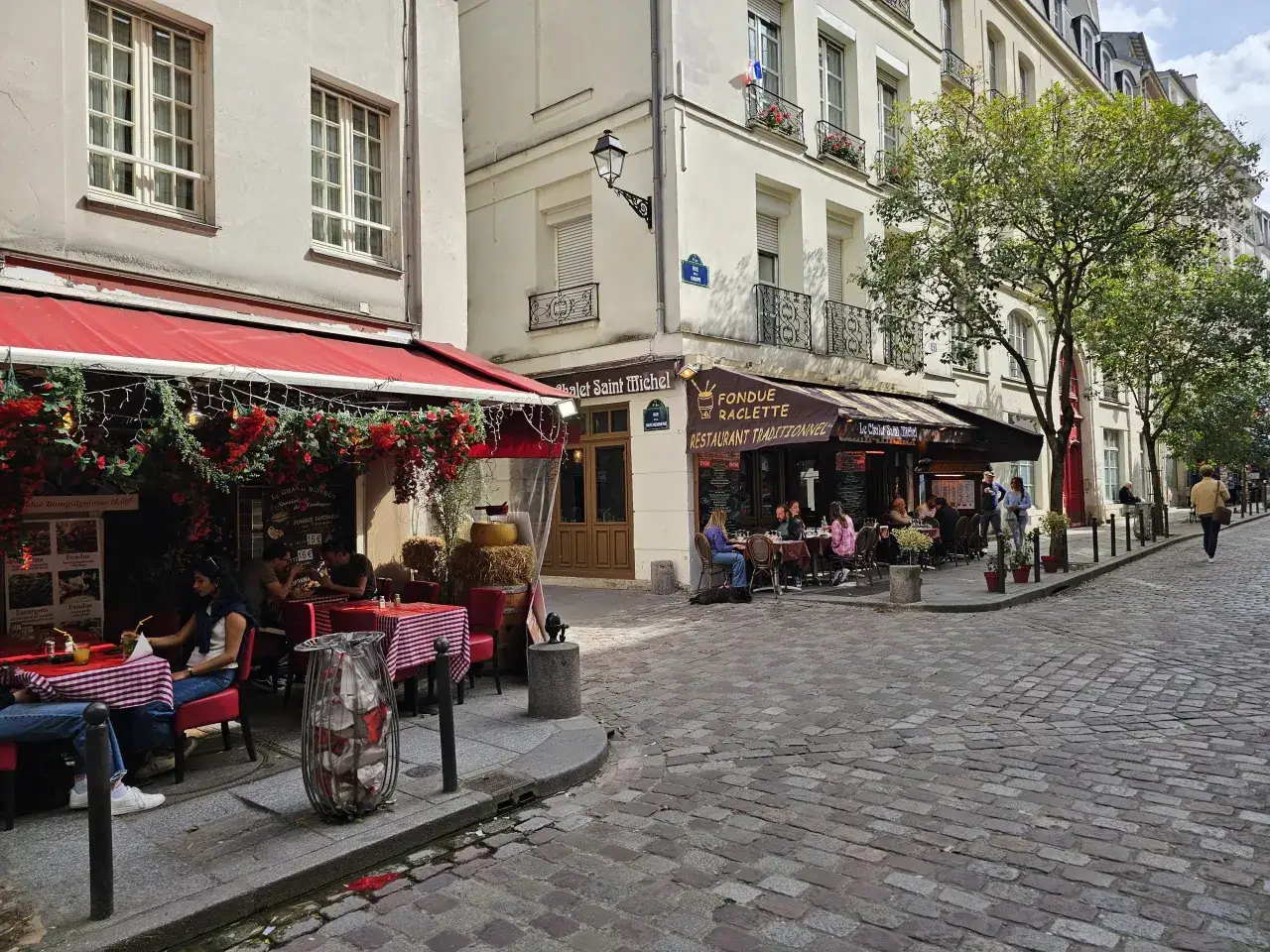 Urokliwa uliczka w 5 dzielnicy Paryża, z kawiarniami i restauracjami zapraszającymi do odpoczynku.