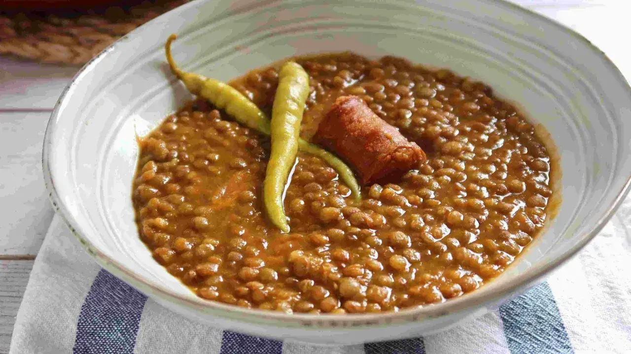 Un plato de lentejas guisadas, cocinadas en olla express, con chorizo y pimientos.