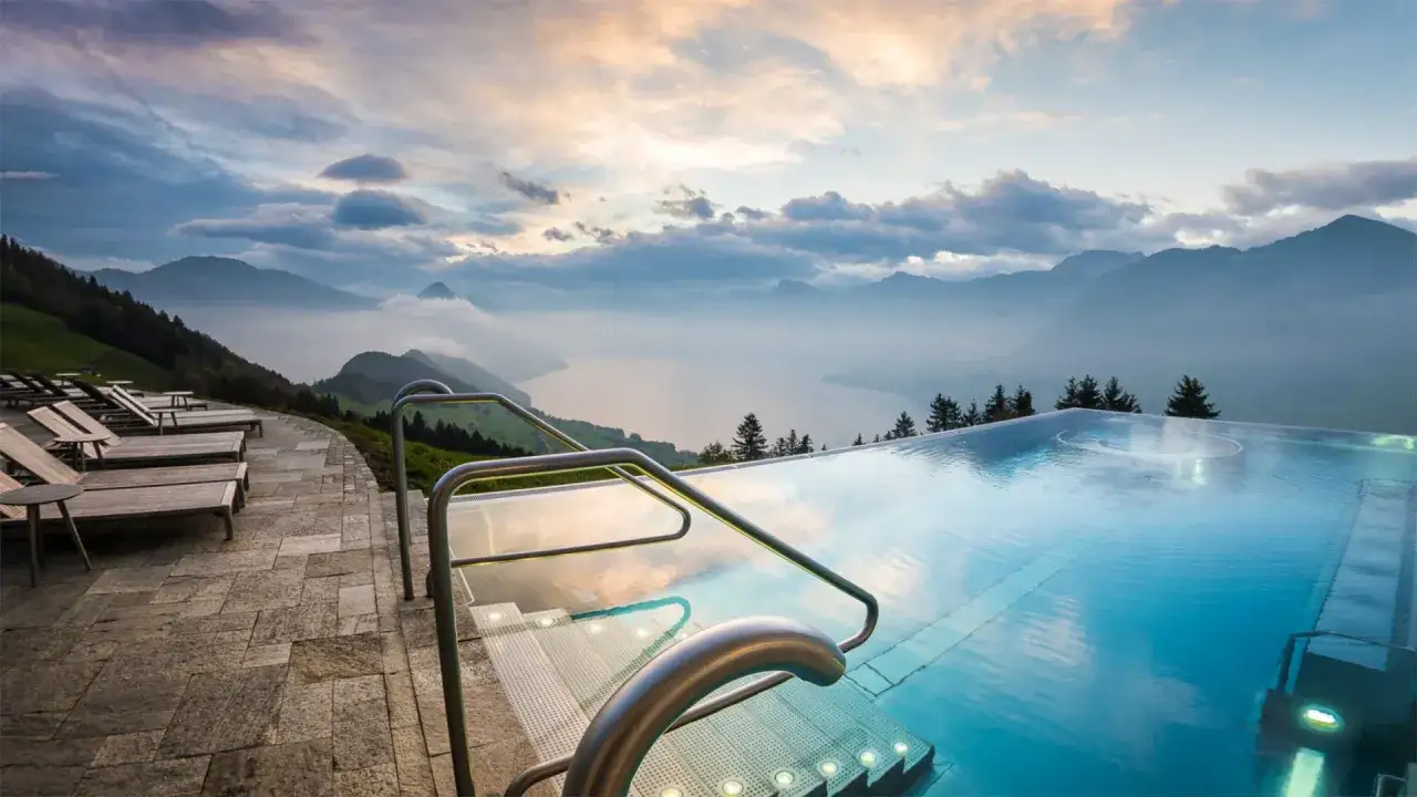 Ein Infinity Pool, der mit dem Horizont verschmilzt, bietet einen atemberaubenden Blick auf Berge und See.