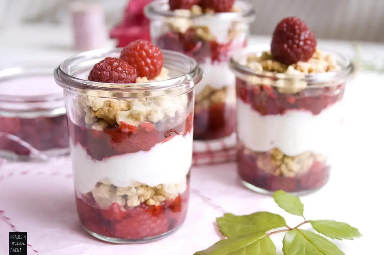 Himbeer Dessert im Glas: geschichtete Leckerei mit frischen Himbeeren, cremiger Joghurt-Schicht und knusprigem Crumble. Ein Genuss f&uuml;r Augen und Gaumen.