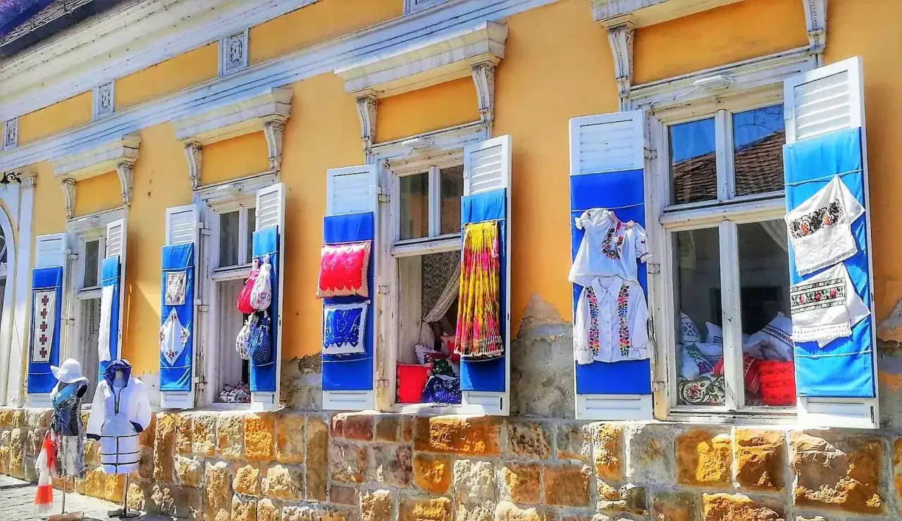 Kolorowe okiennice i tradycyjne stroje ozdabiają fasadę budynku, tworząc urokliwy widok. Szentendre atrakcje zachwycają!