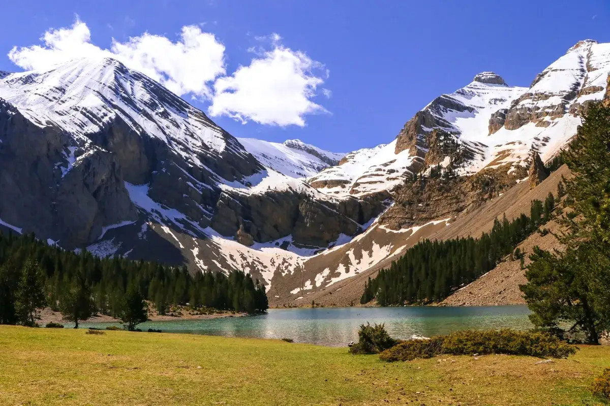 Majestuoso ibón de Plan, rodeado de montañas nevadas y bosques. Un paisaje perfecto para una ruta circular.
