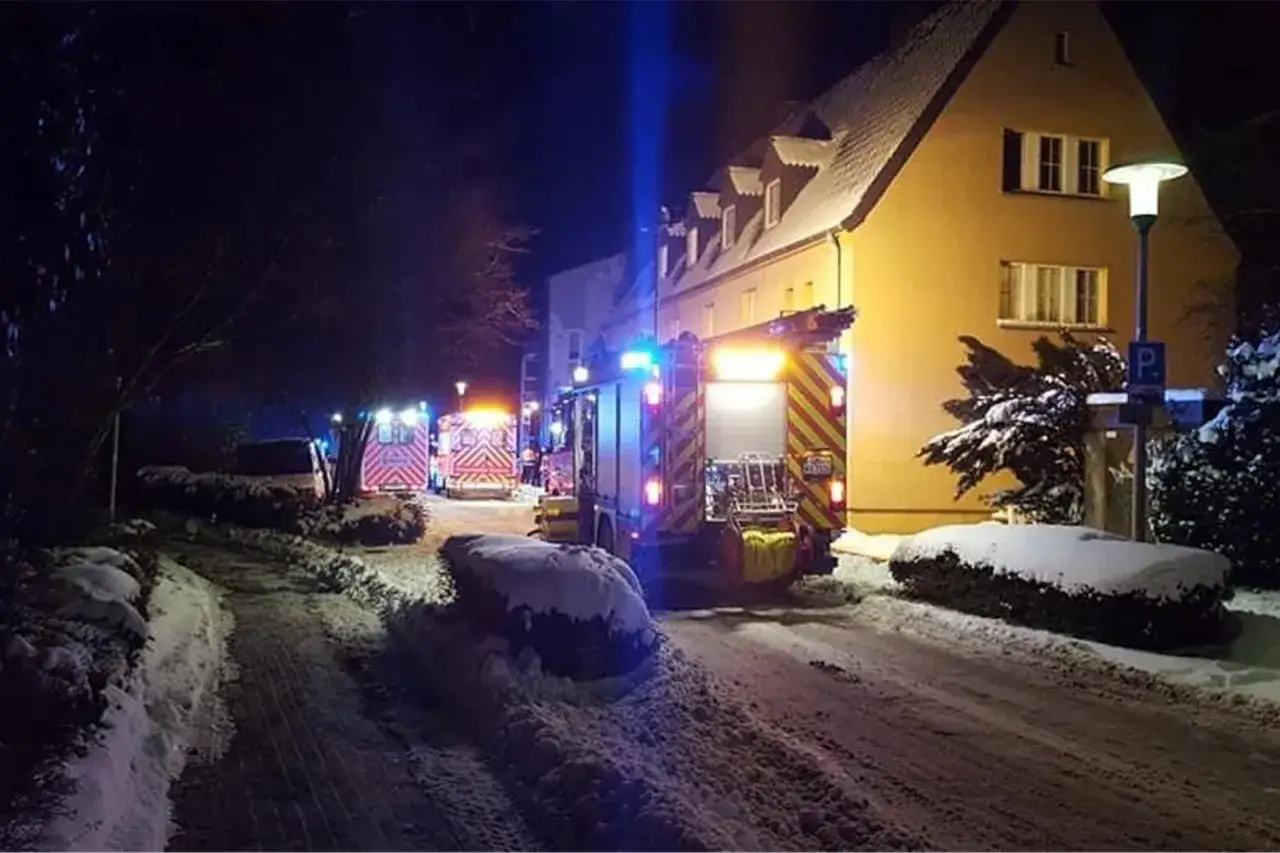 Einsatzkräfte vor einem Haus bei Nacht. Ein Feuerwehrauto und ein Krankenwagen mit Blaulicht. Ein missglücktes Experiment: Grillen in der Wohnung?