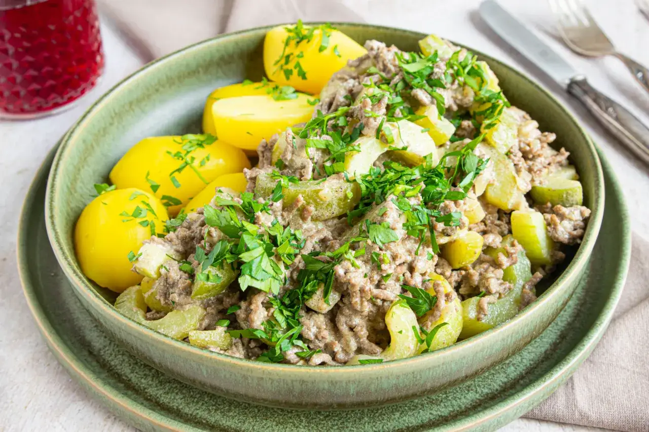 Herzhaftes Gericht mit Schmorgurken mit Hackfleisch und Salzkartoffeln, garniert mit frischer Petersilie.