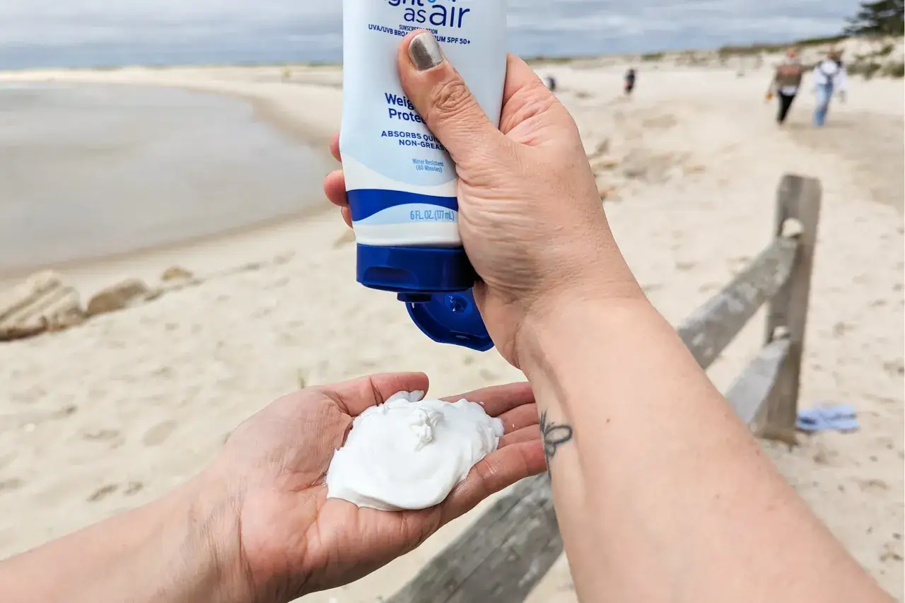 Sonnencreme wird auf die Hand gegeben, um sie mehrmals aufzutragen. Am Strand ist Sonnenschutz wichtig.