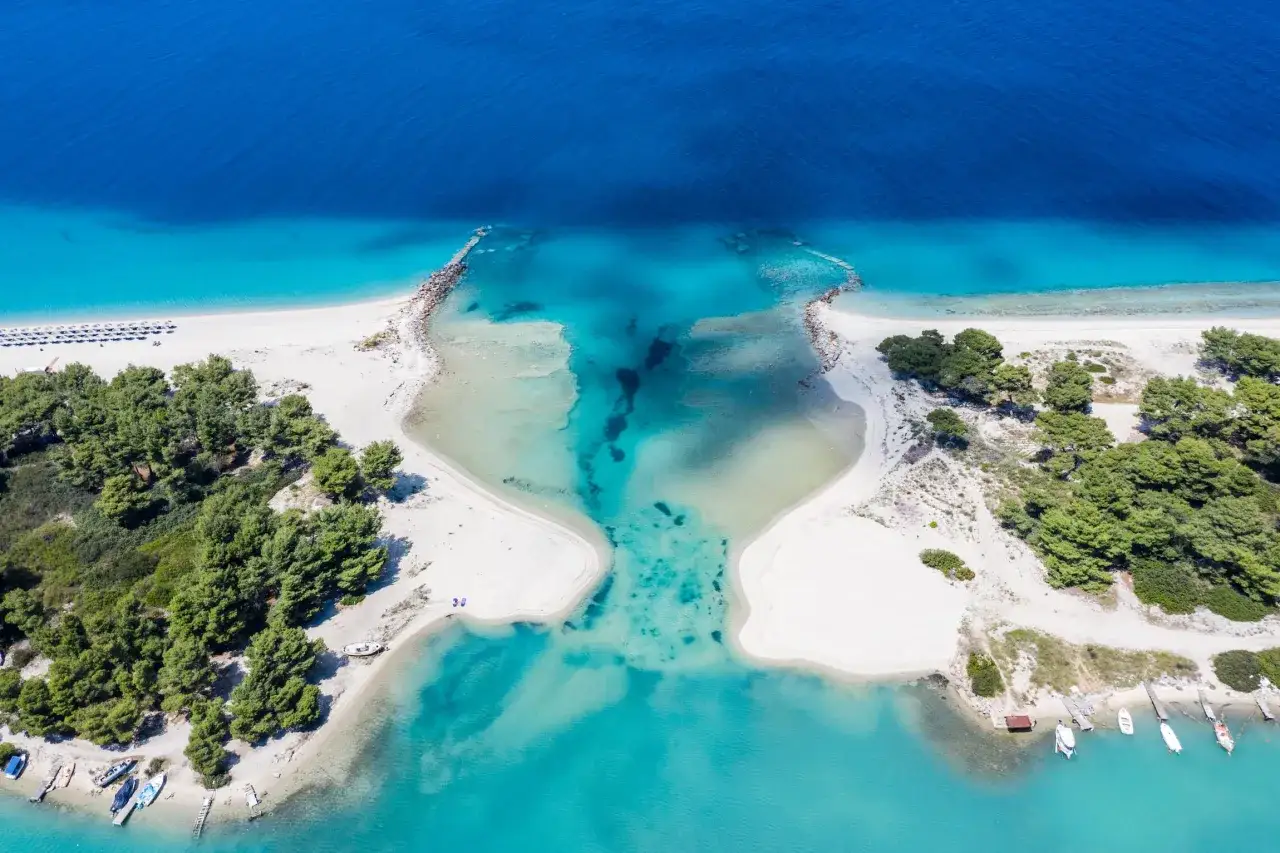 Widok z lotu ptaka na turkusowe wody i białe plaże Chalkidiki. Czy warto tam jechać? Zdecydowanie tak!