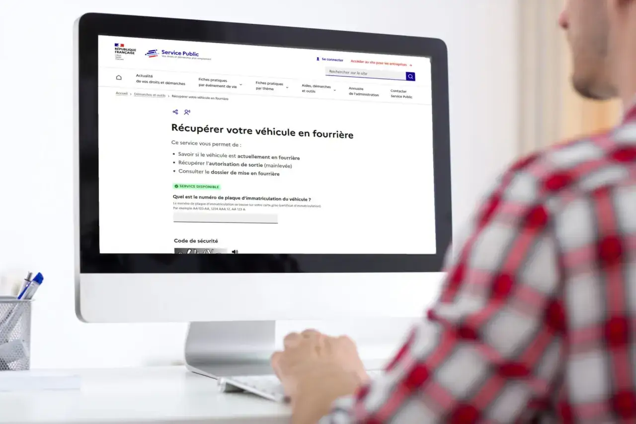 Un homme consulte le site Service Public pour récupérer son véhicule en fourrière sans PV.