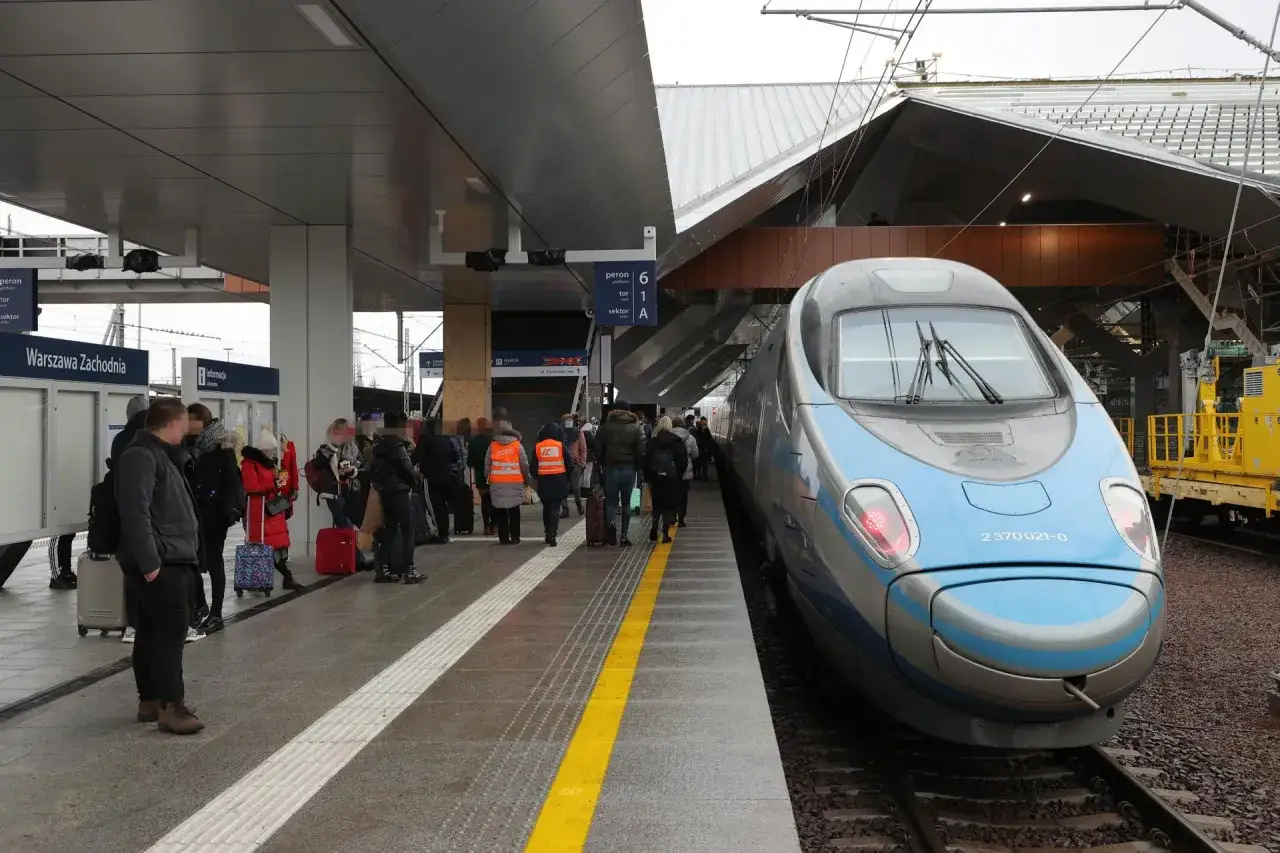 Pendolino na dworcu Warszawa Zachodnia. Pasażerowie z bagażami czekają na peronie na szybki pociąg.