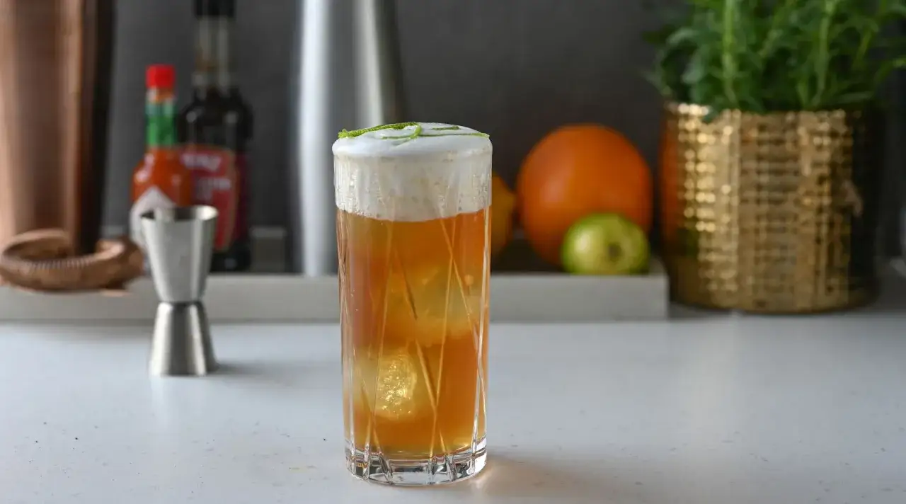 En hög, skummande drink med is, garnerad med lime. Kanske en Fidel Castro drink?