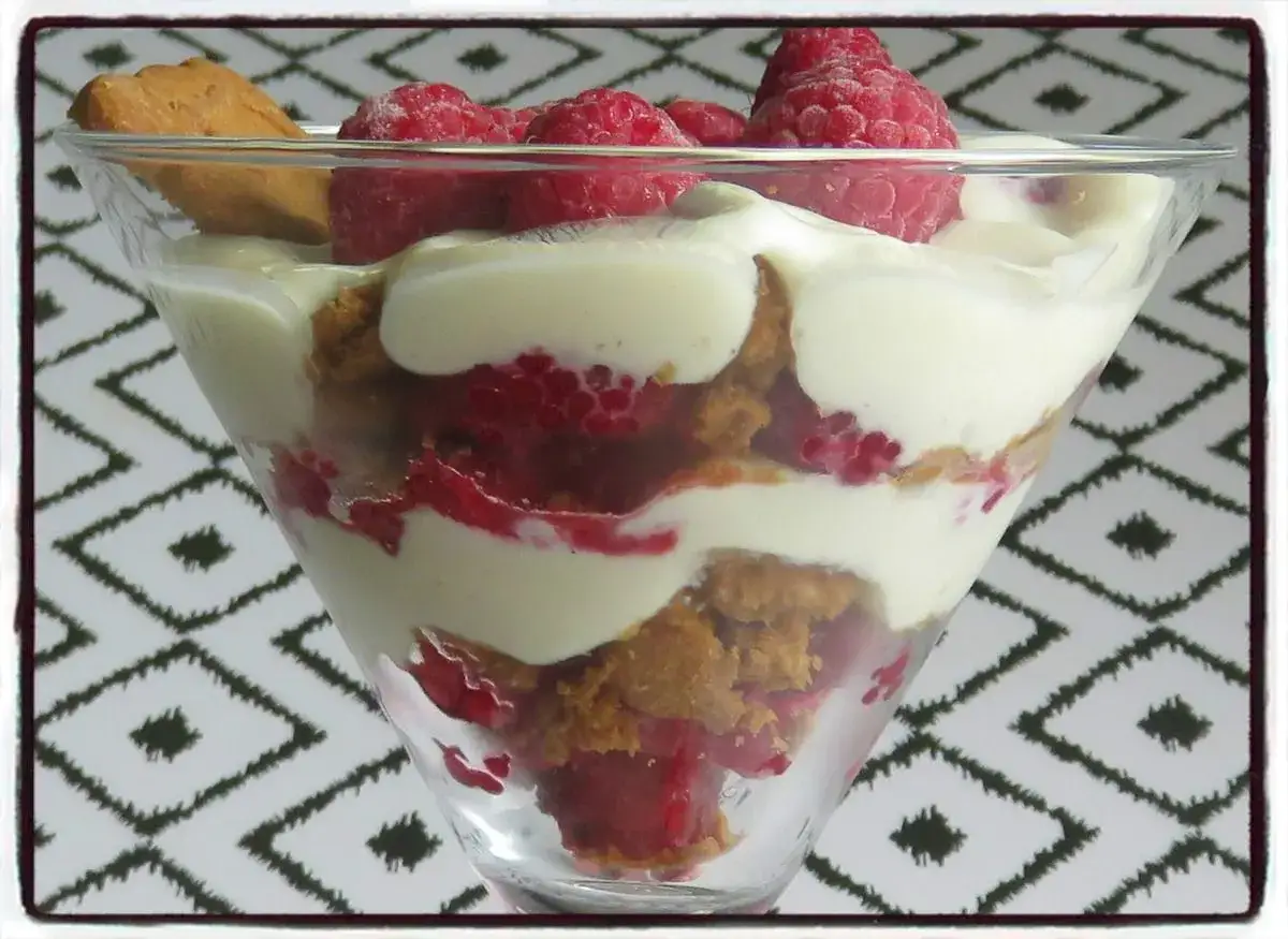 Délicieux cheesecake sans cuisson en verrine, alternant couches de biscuits émiettés, framboises fraîches et crème onctueuse.