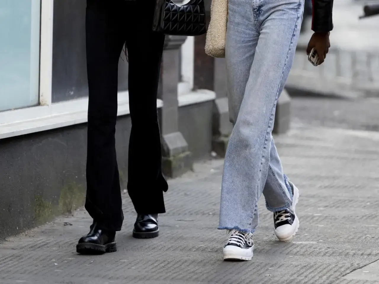 Zwei Damen zeigen, wie man hohe Chucks kombiniert: eine mit l&auml;ssiger Jeans, die andere mit eleganten schwarzen Hosen.