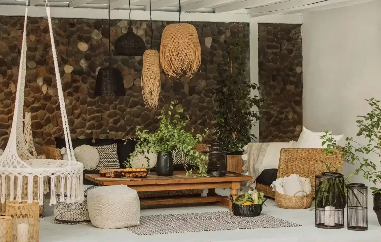 Gemütliches zimmer im boho style mit Hängesessel, Rattanmöbeln und vielen Pflanzen.