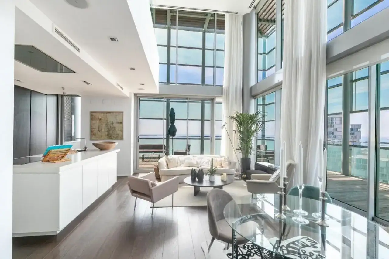 Luksusowe penthouses co to? Przestronny salon z widokiem na morze, nowoczesna kuchnia i jadalnia.