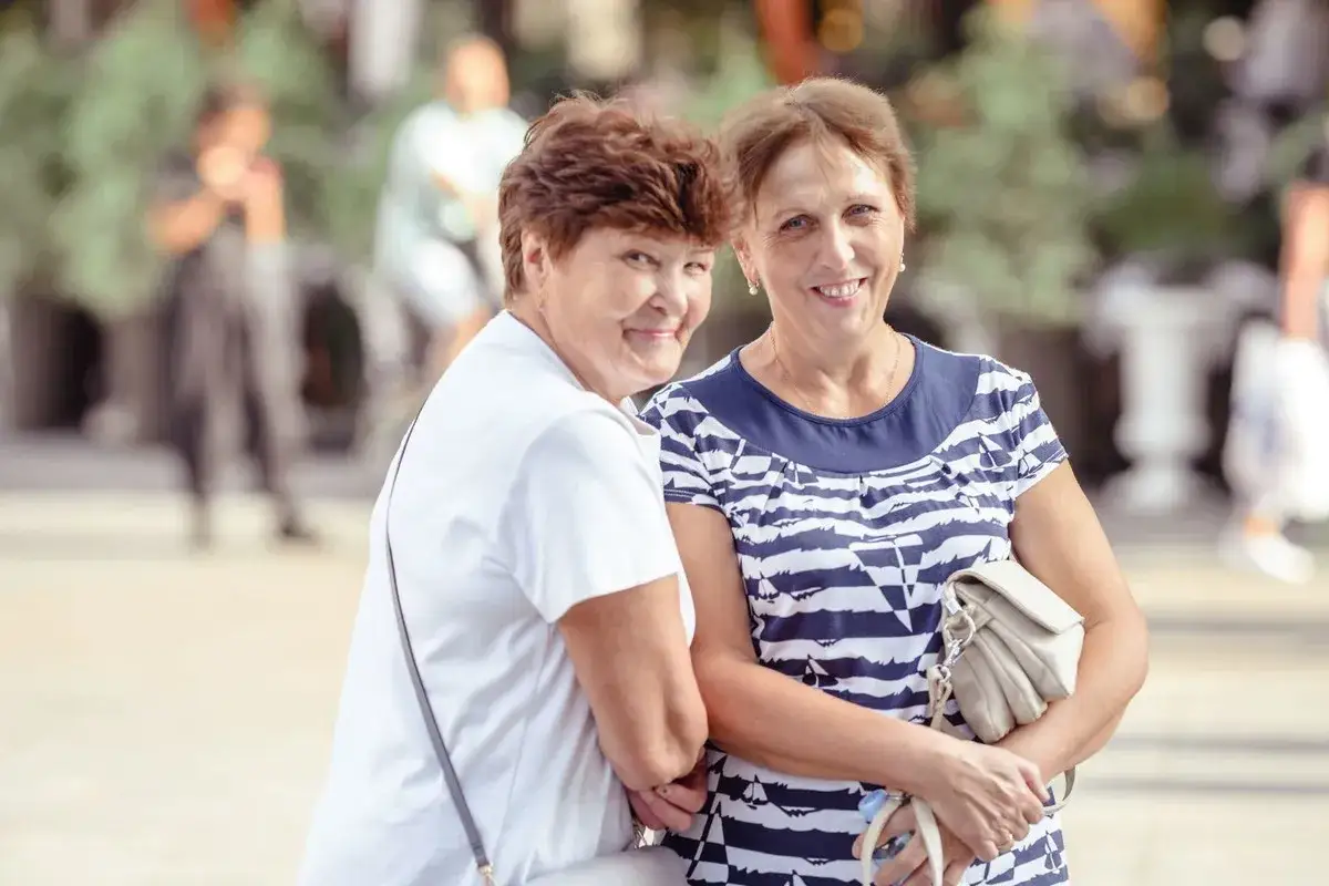 Dwie uśmiechnięte kobiety, emanujące pozytywną energią, to świetny przykład cech ekstrawertyka.