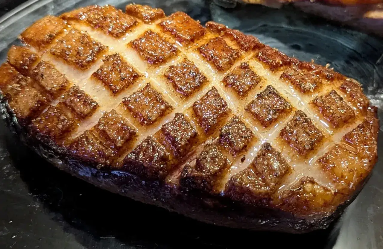Magret de canard au four, la peau grillée en losanges, prête à être dégustée.