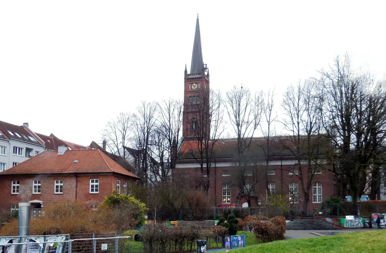 Der St. Pauli Dom ragt mit seinem Turm über Bäume und Gebäude.