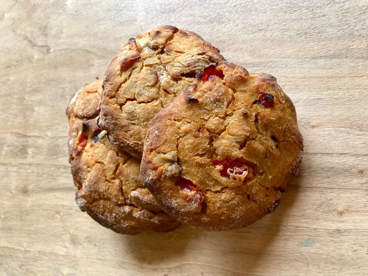 Tre rustici **pane e pomodoro** **campi salentina**, dorati e fragranti, su un tagliere di legno.