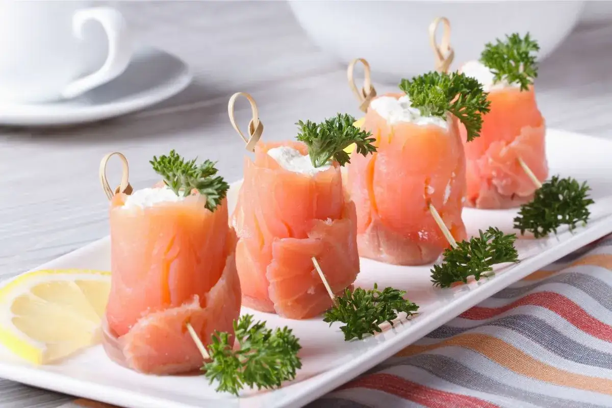 Rotolini di salmone affumicato con formaggio cremoso e prezzemolo, perfetti per ricette fredde.