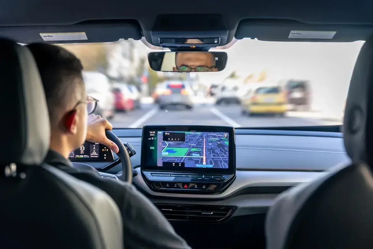 Conducteur concentré sur la route, utilisant le GPS. Il pense à sa lettre de motivation pour devenir conducteur de voiture radar.