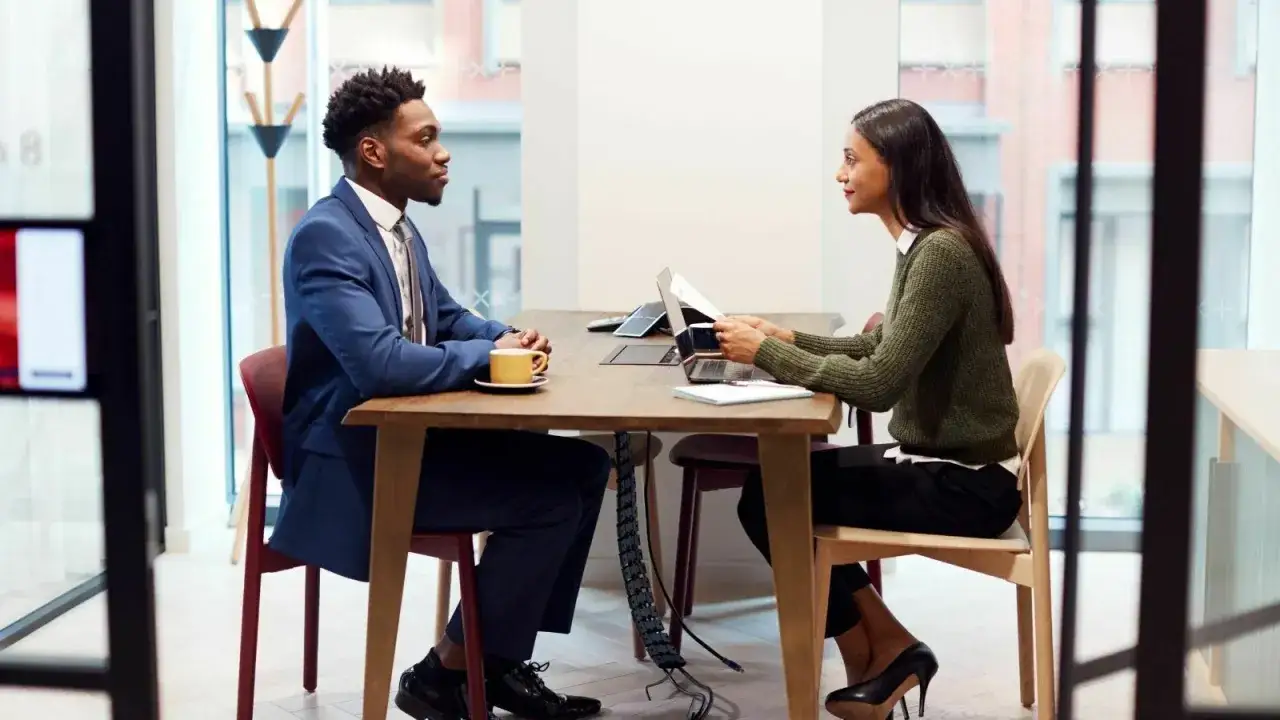 Uomo e donna discutono di un progetto di lavoro in banca.