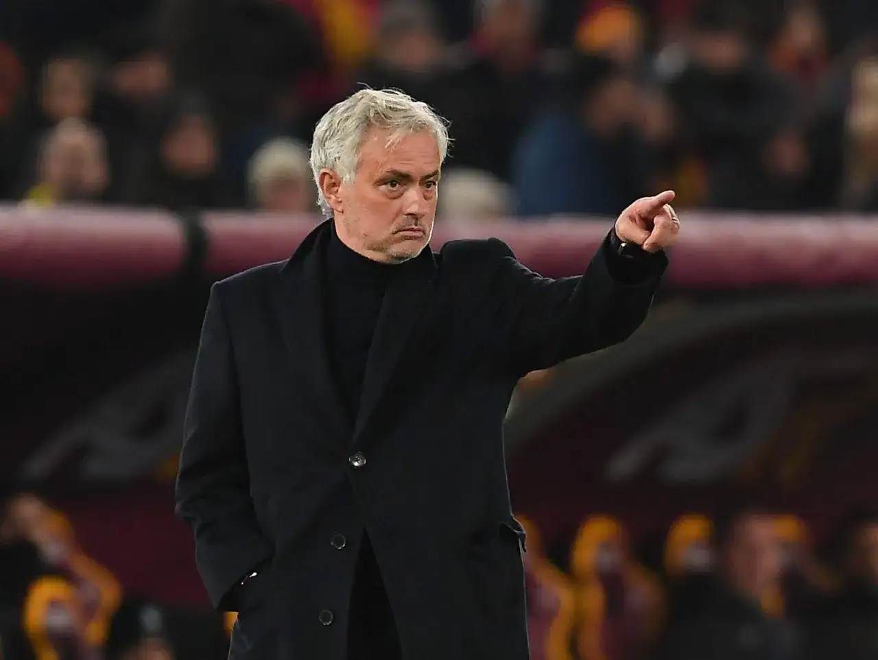 José Mourinho, znany z prowadzenia drużyn, wskazuje palcem na boisko, skupiony na grze.