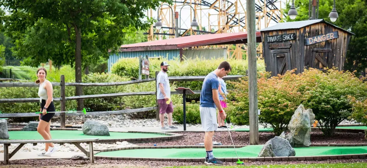 Folk spelar minigolf p&aring; en wow park. En gammal 