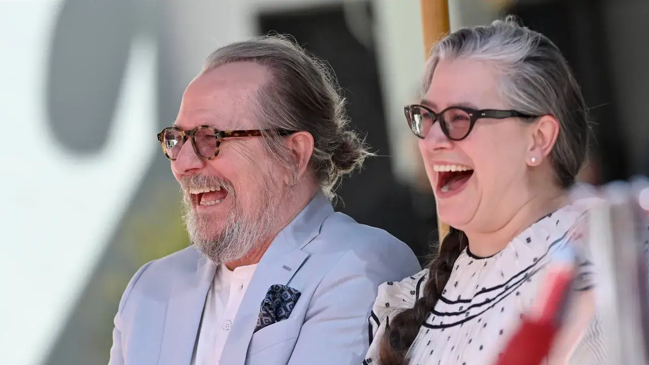 Gary Oldman i jego żona śmieją się radośnie.