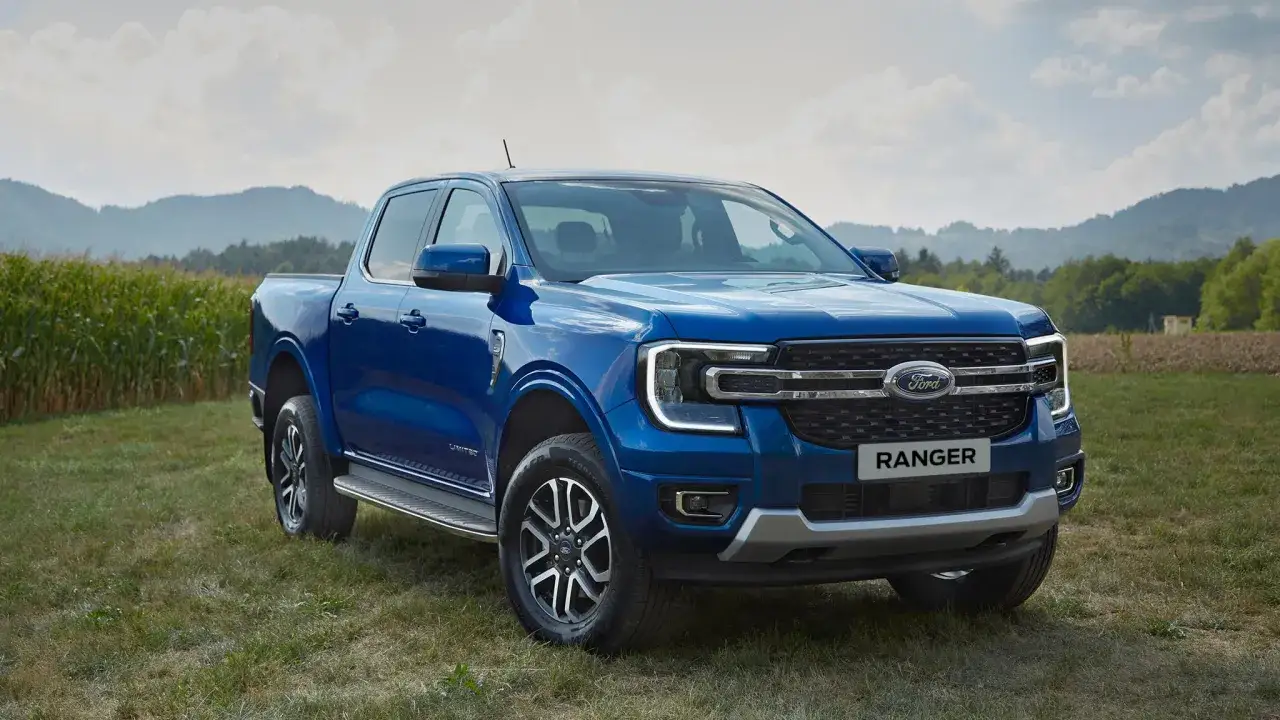Niebieski Ford Ranger na tle pól i wzgórz. Ten model to tylko jeden z wielu dostępnych modeli Forda, gotowy na każdą przygodę.