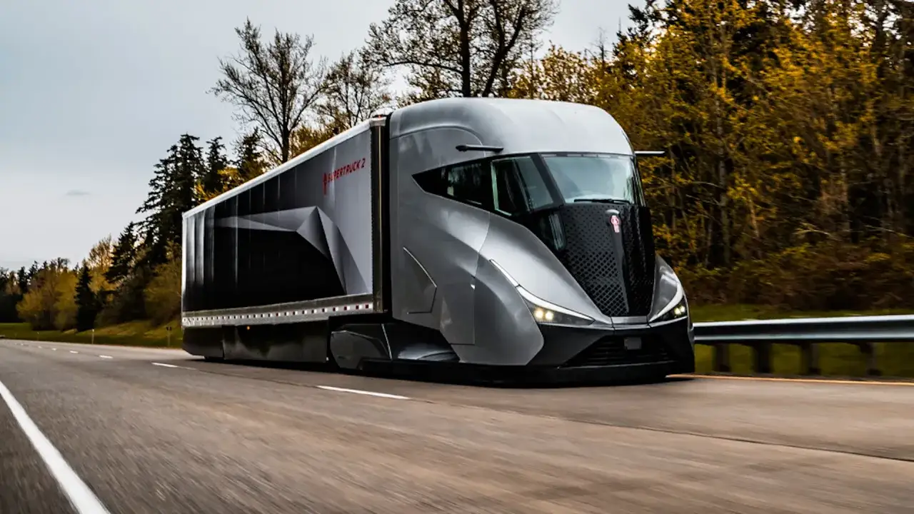 Un camion du futur, gris et a&eacute;rodynamique, roule sur une autoroute bord&eacute;e d'arbres aux couleurs automnales.