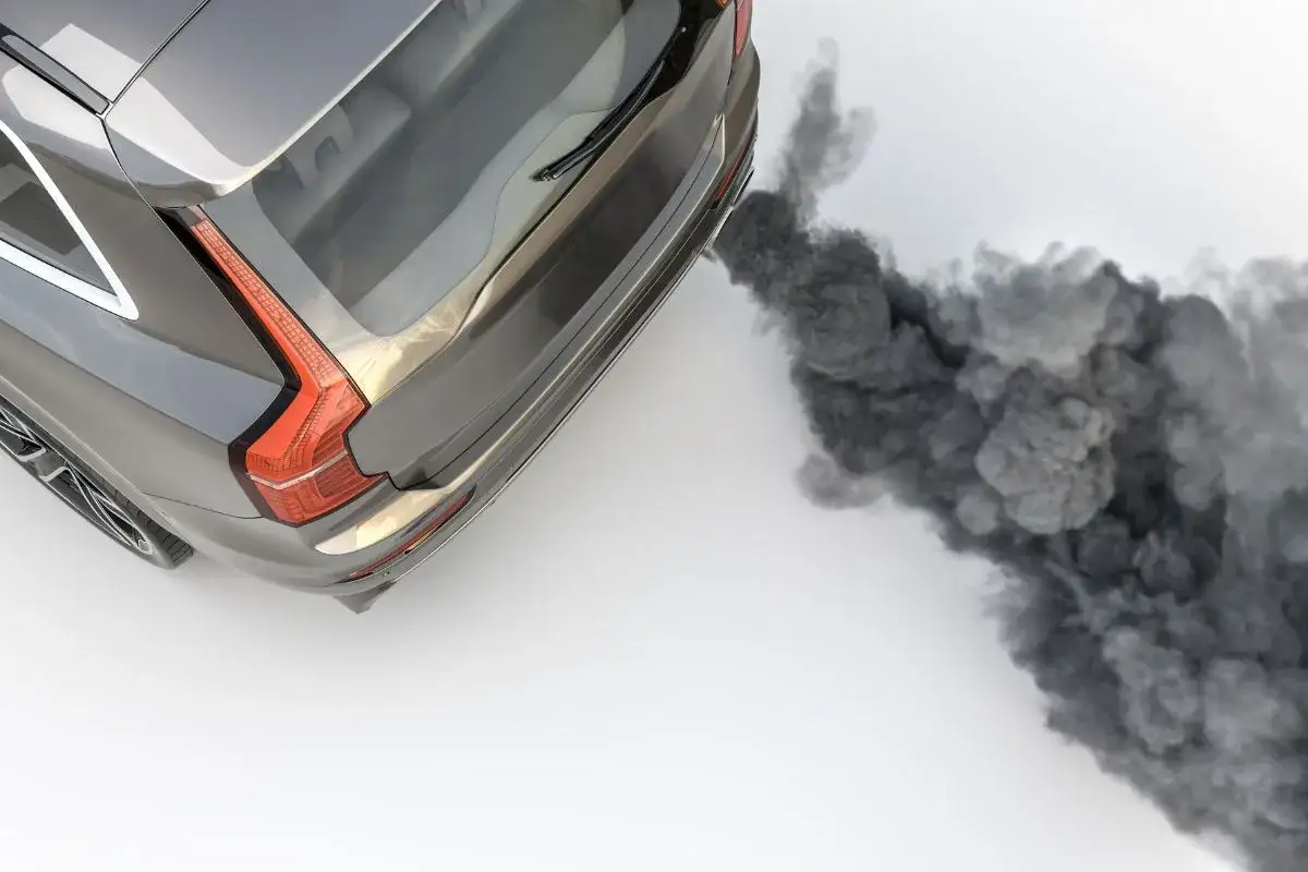 Un coche diésel emite una densa nube de humo negro al arrancar, contaminando el aire.