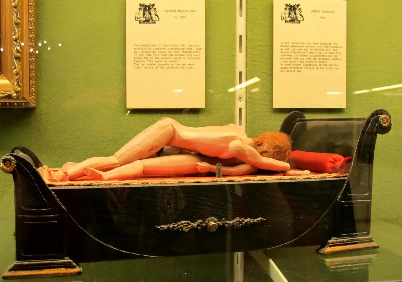 Drewniane łóżko z pozytywką z XIX wieku, eksponat w muzeum seksu w Amsterdamie, z ruchomymi figurkami.
