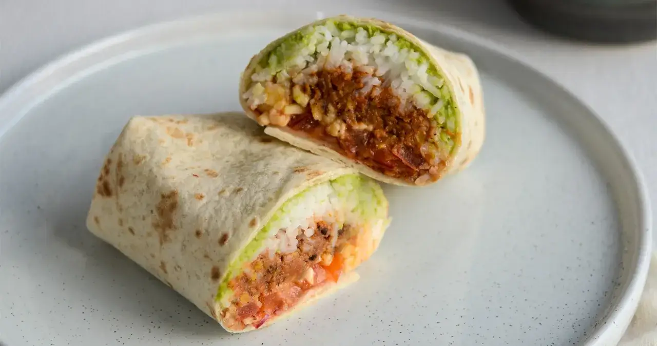 En skuren burrito med ris, guacamole och kryddig k&ouml;ttf&auml;rs. Perfekt f&ouml;r att l&auml;ra sig como hacer burritos de res.
