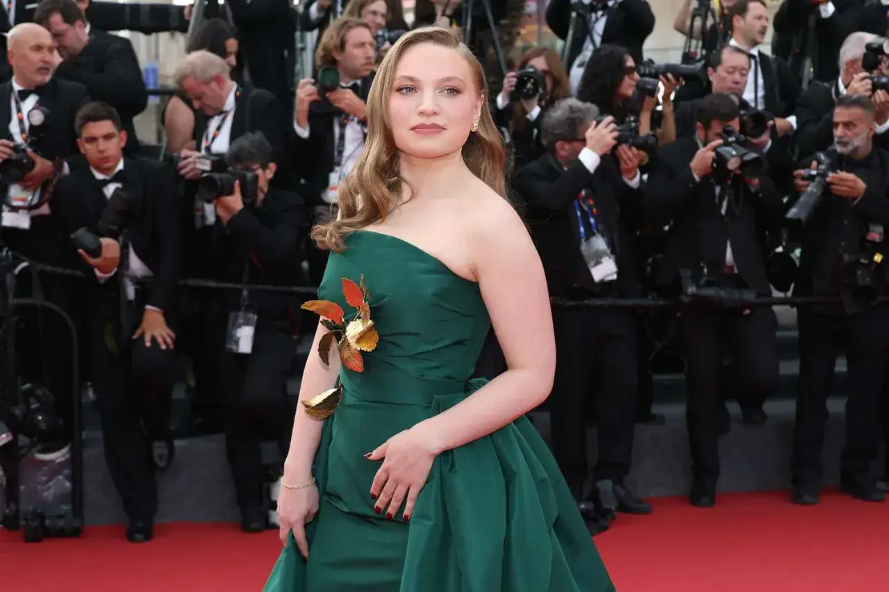 Mia Threapleton desfila en la alfombra roja con un vestido verde esmeralda, rodeada de fot&oacute;grafos.