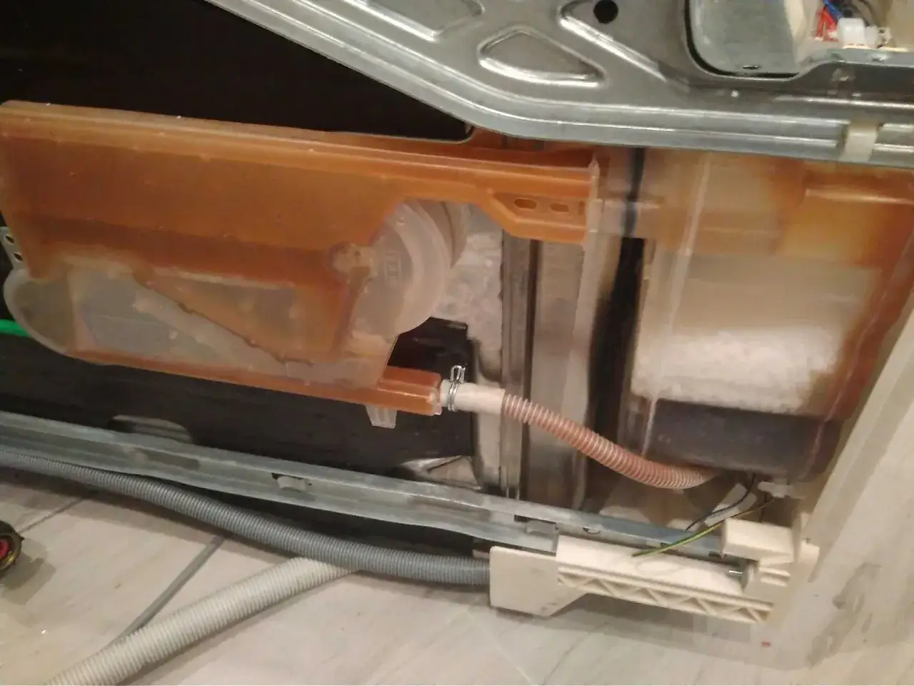 Zmywarka Electrolux z błędem i20. Widoczny brudny zbiornik na wodę i zapchany filtr.