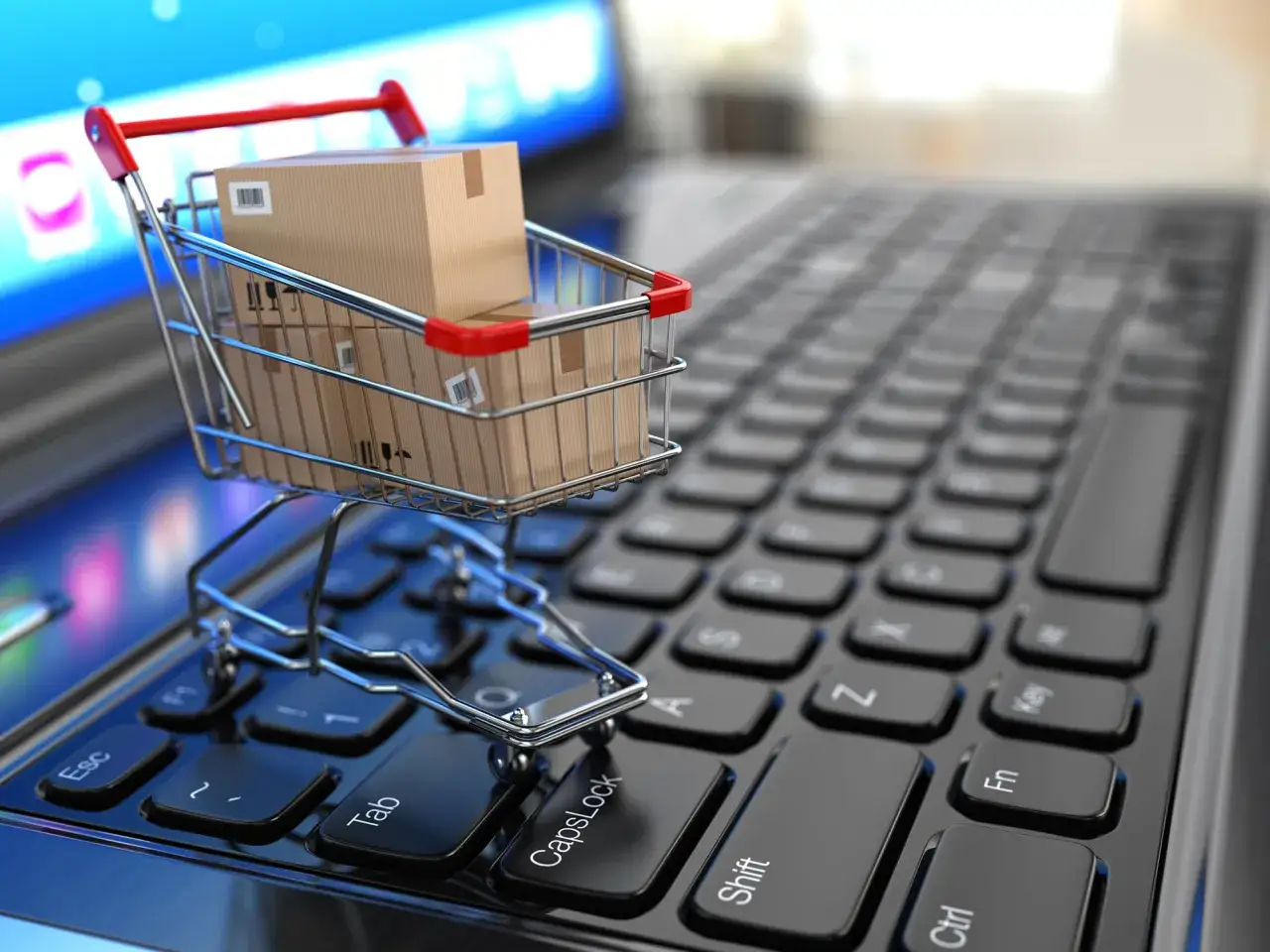 Carrito de compras con cajas sobre un teclado de laptop, simbolizando los requisitos legales para abrir una tienda online.