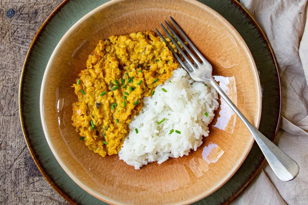 Un plat réconfortant de riz blanc et de lentilles corail épicées, garni de ciboulette fraîche. Un délice simple et savoureux.