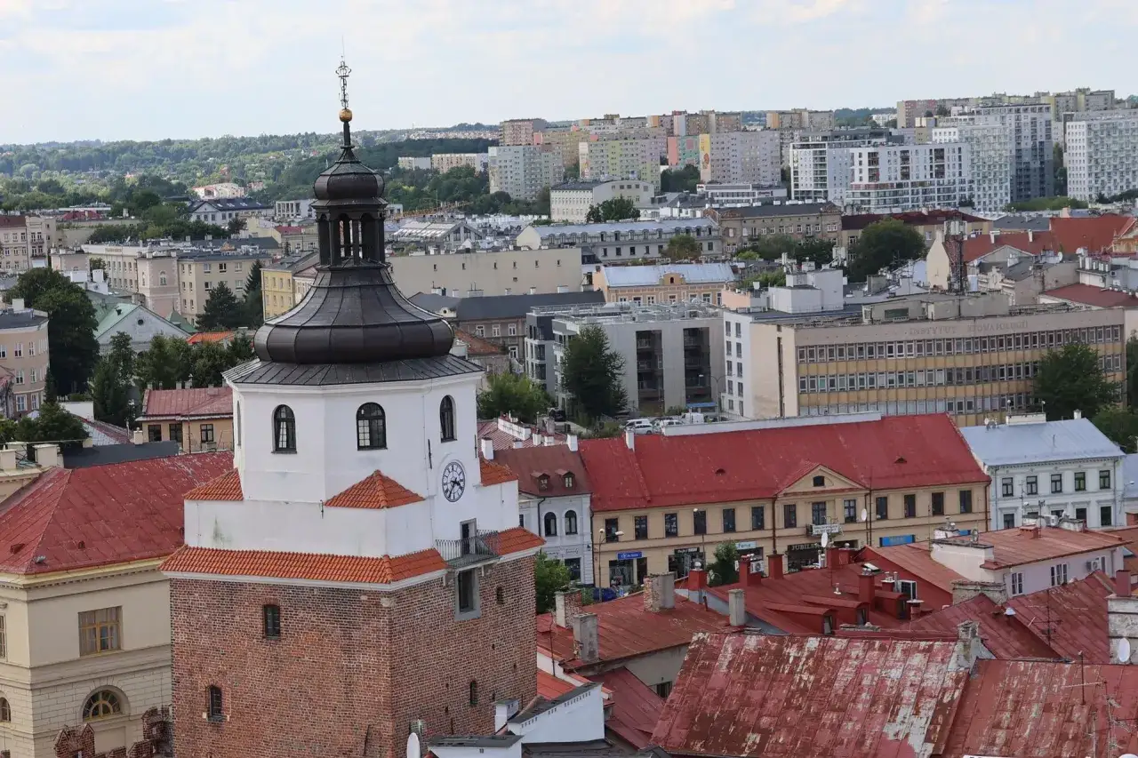 Widok na miasto z wieżą trynitarską w centrum. W tle zabudowa mieszkalna i budynki użyteczności publicznej.