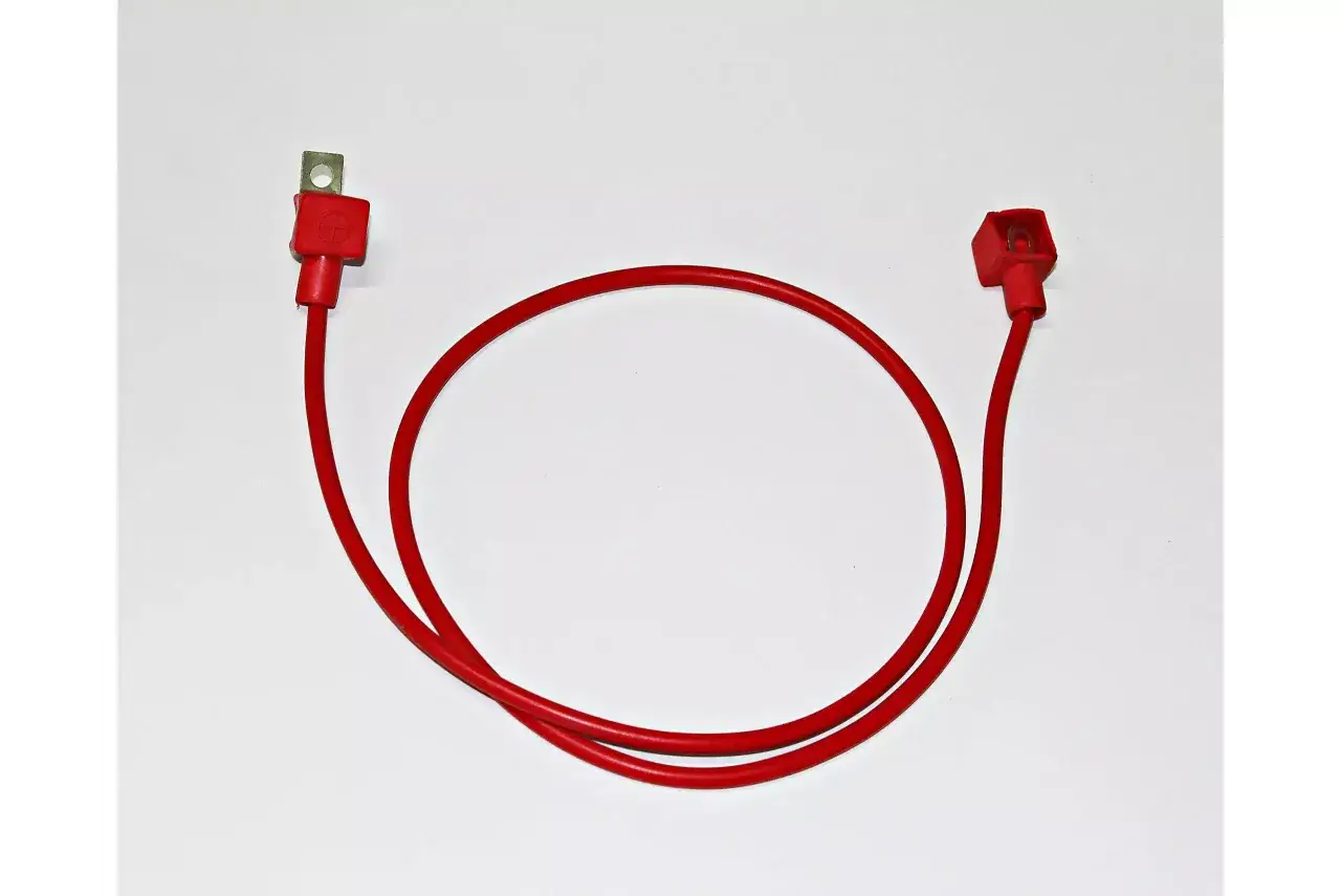 Czerwony kabel z końcówkami do akumulatora. Czy czerwony to plus czy minus? Zazwyczaj tak, ale warto sprawdzić oznaczenia.